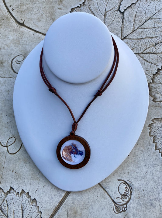 Desert Gold features an image of a chestnut Arabian horse set behind crystal dome in a wood bezel suspended by hand knotted satin cord. 