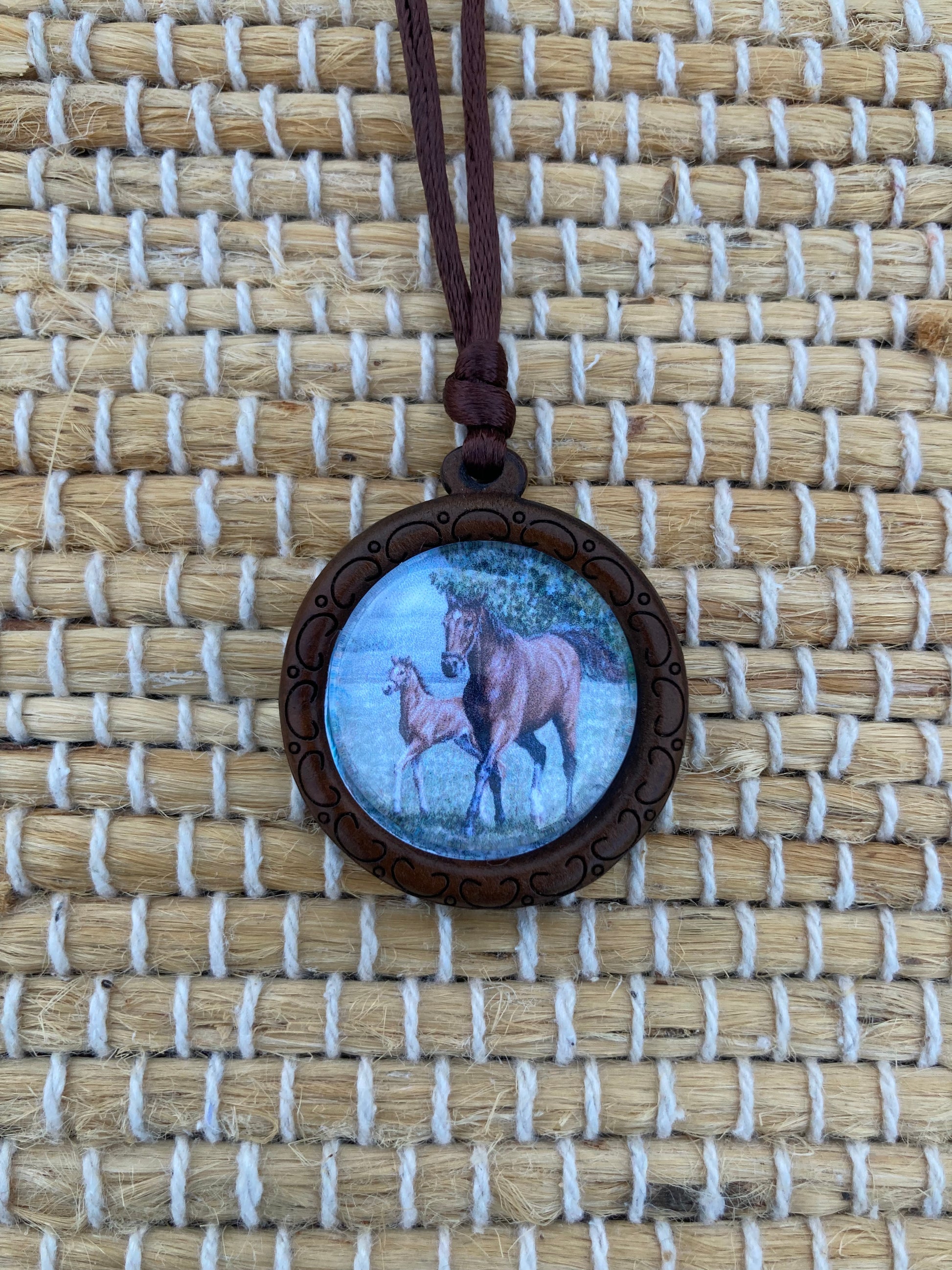 Mother's Day Equestrian Keepsake pendant featuring original artwork by Salina Ramsay of a mare and foal beneath a crystal setting, symbolizing the timeless bond between mother and child.