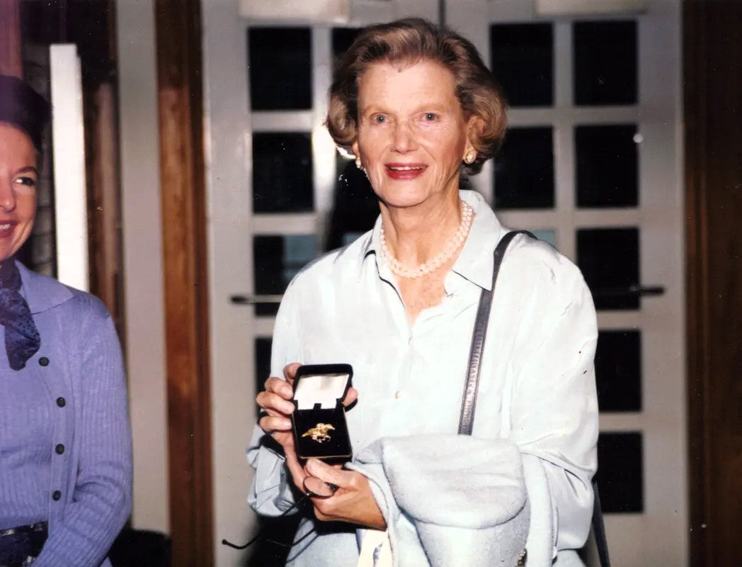 Penny Chenery holding the original 18k Secretariat Pin — Salina Ramsay Studio current edition 14k solid gold