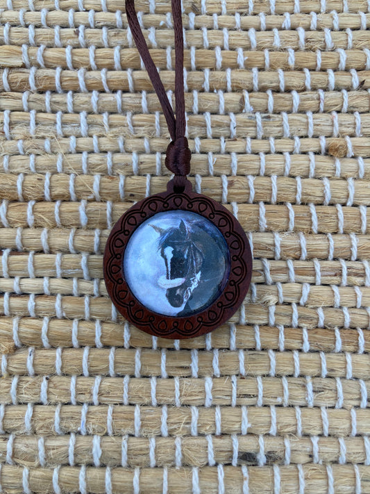 The smaller Zenyatta Equestrian Keepsake Pendant featuring a reproduction of Salina Ramsay's original artwork beneath a crystal setting. Inspired by the legendary racing mare Zenyatta, this collectible pendant from The Fillies Collection captures the grace, strength, and enduring spirit of one of Thoroughbred racing's most beloved champions.